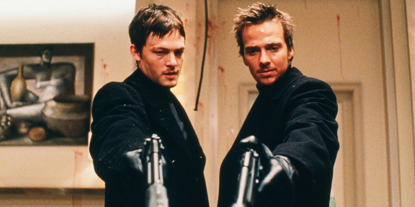 Norman Reedus as Murphy MacManus and Sean Patrick Flanery as Connor MacManus pointing guns down in The Boondock Saints