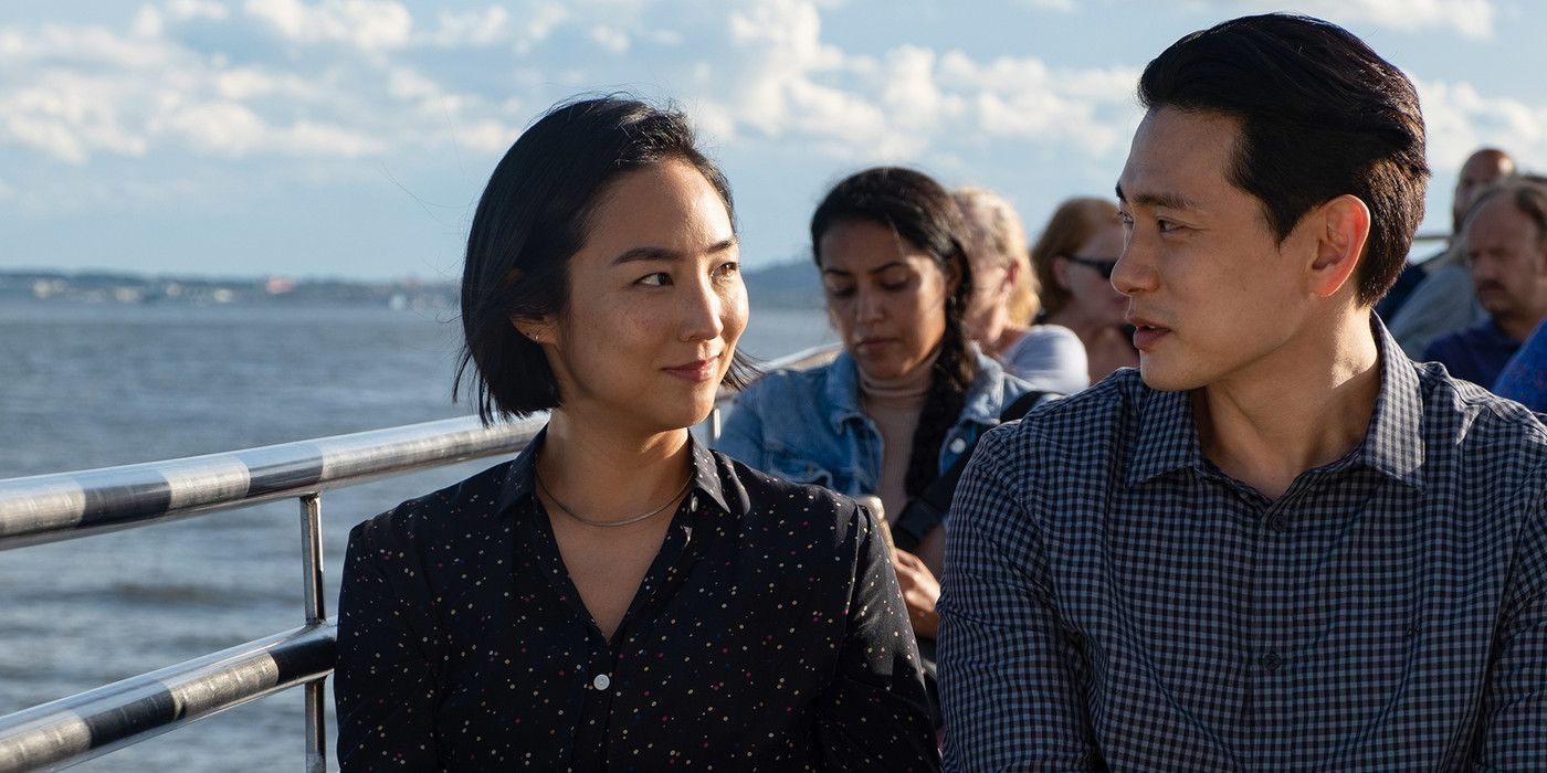 Greta Lee and Teo Yoo looking at each other on a ferry in Past Lives
