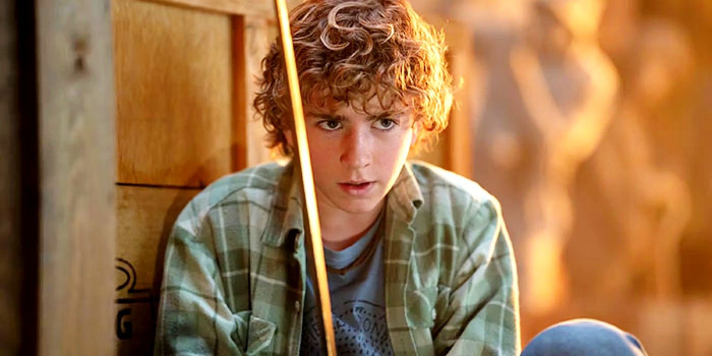 Walker Scobell as Percy Jackson with an intense look on his face while holding up his sword.