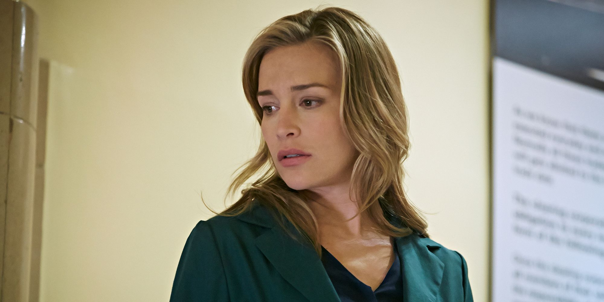 Piper Perabo is looking towards the ground with a worried look on her face. 