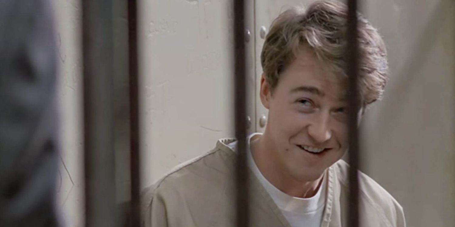 Edward Norton como Roy/Aaron em uma cena média sorrindo atrás das grades em Primal Fear