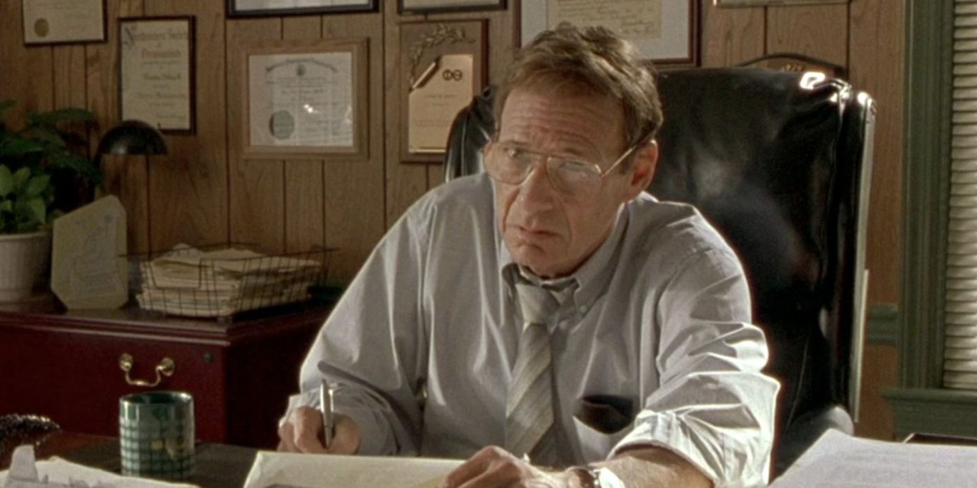Ron Leibman as Dr. Cohen, sitting and writing at a desk in Garden State.