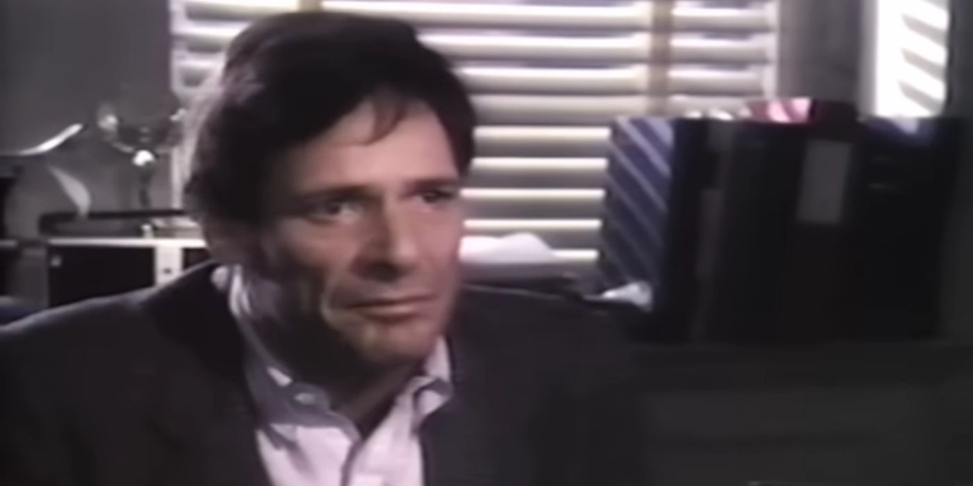 Ron Leibman as Morris Huffner, sitting at a desk and looking serious, in Christmas Eve.