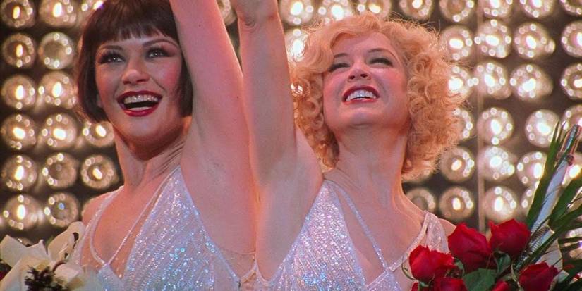 Catherine Zeta-Jones as Roxie and Renee Zellweger as Velma holding flowers and holding hands in Chicago
