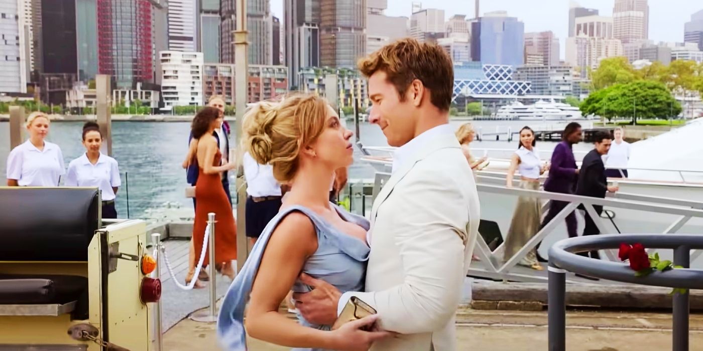 Sydney Sweeney and Glen Powell hold each other romantically on a dock in Anyone But You.