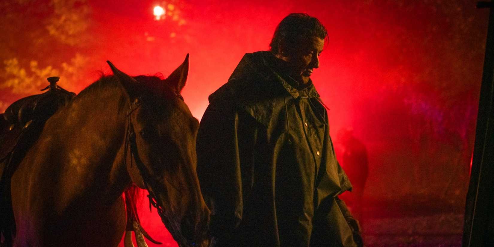 Sylvester Stallone stands with a horse as Rambo in Rambo: Last Blood (2019)
