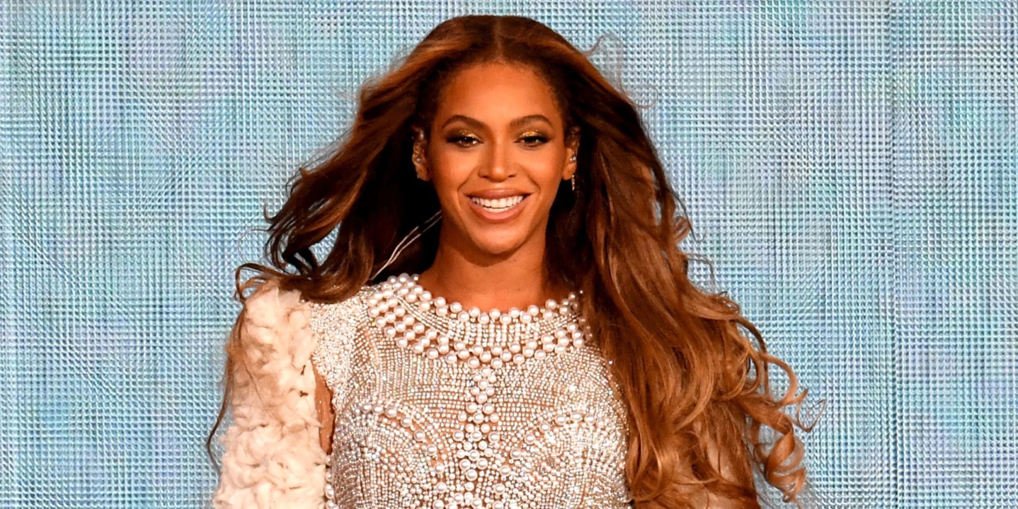 Beyonce está sonriendo en el escenario. 
