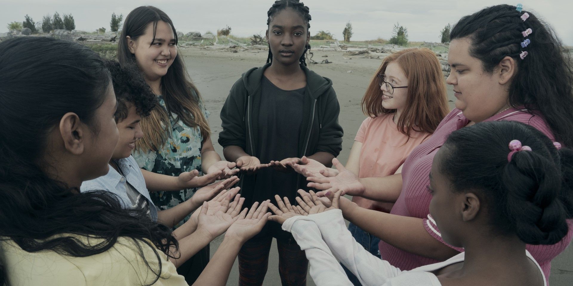 Teenage girls standing in a circle showing their hands in The Power