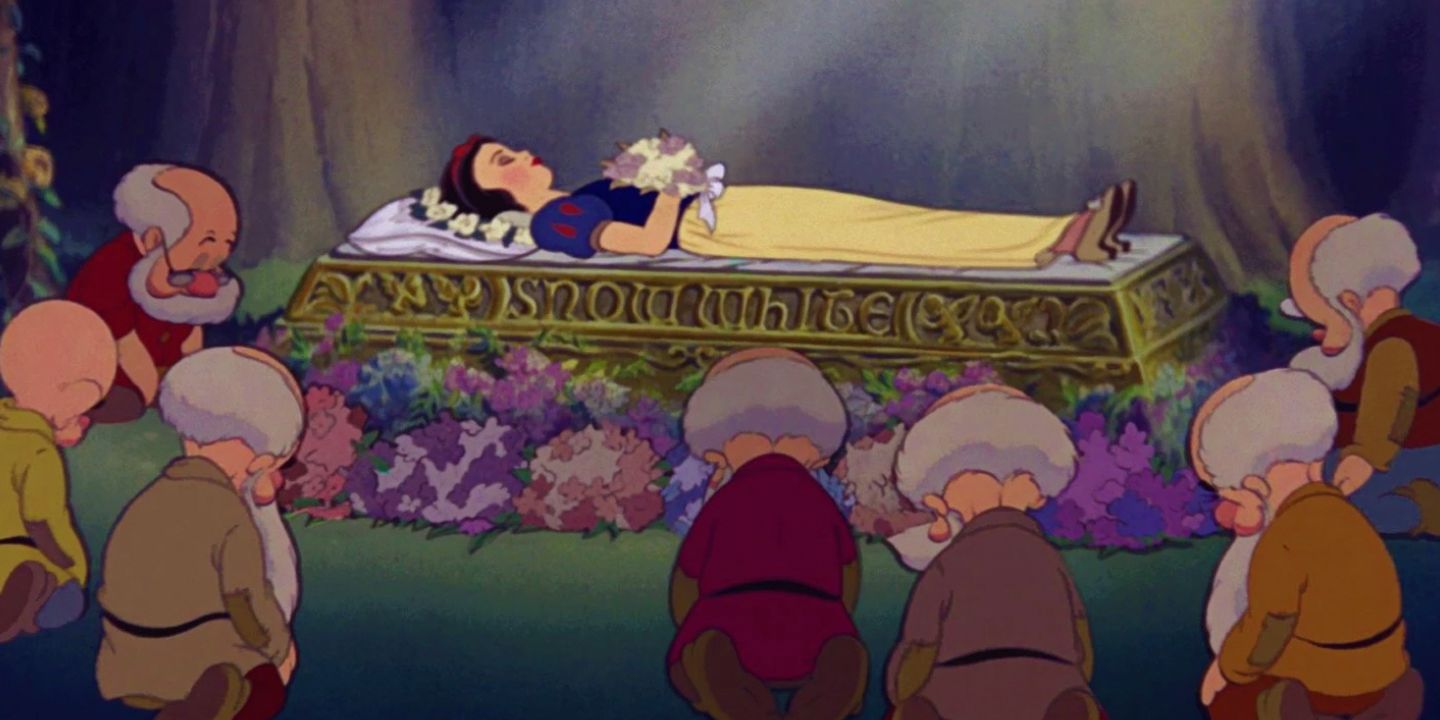 The dwarfs kneeling around a sleeping Snow White