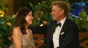 Theresa Nist and Gerry Turner from The Golden Bachelor laughing and looking at each other on bench