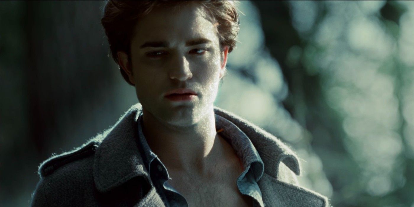 Edward stands in the forest with sunlight rising behind him in twilight