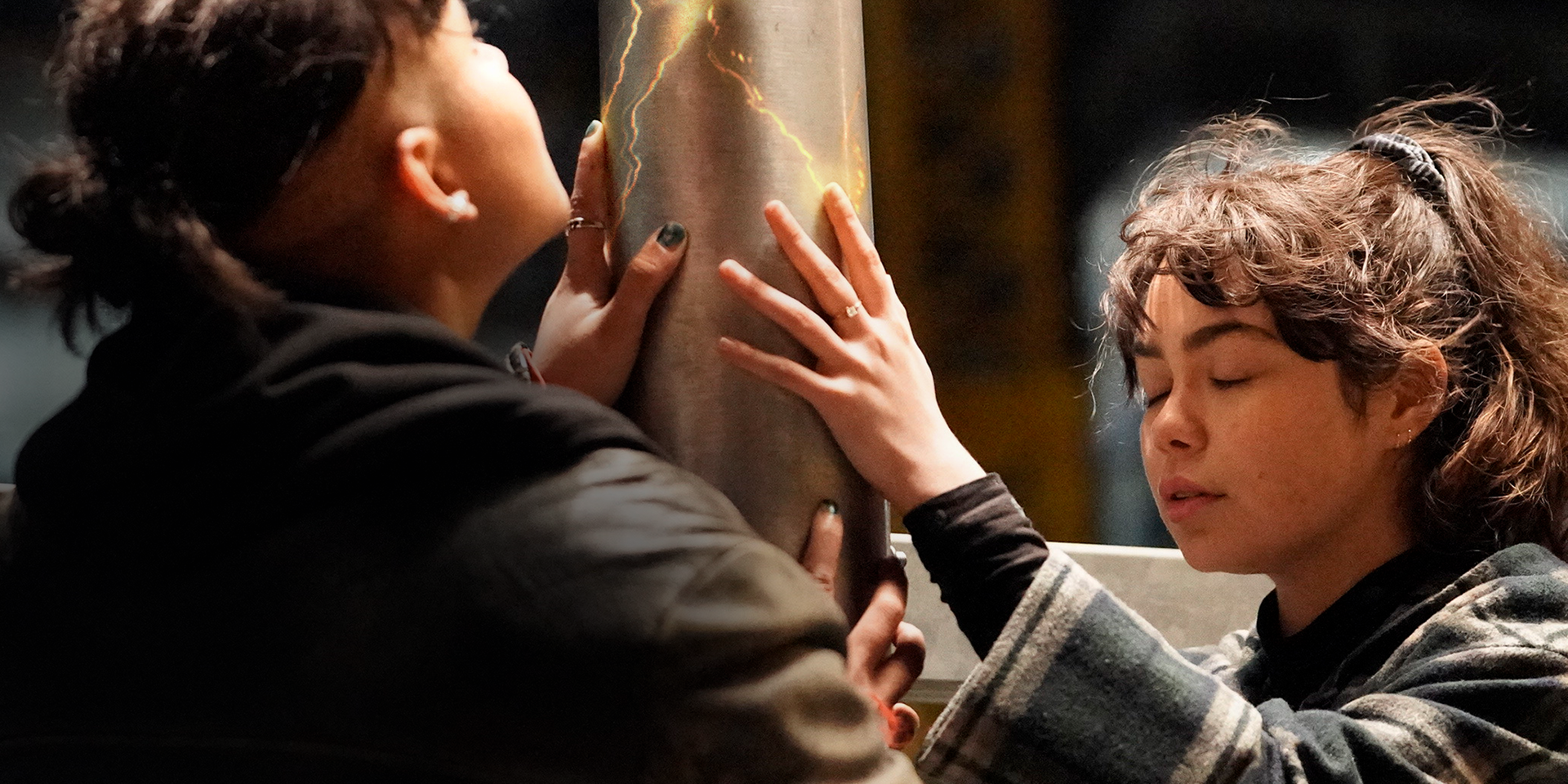 Two people holding a pole in The Power