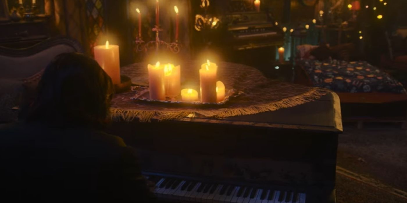 WWDITS Laszlo playing piano by candlelight, with Child Colin Robinson's bed in the background