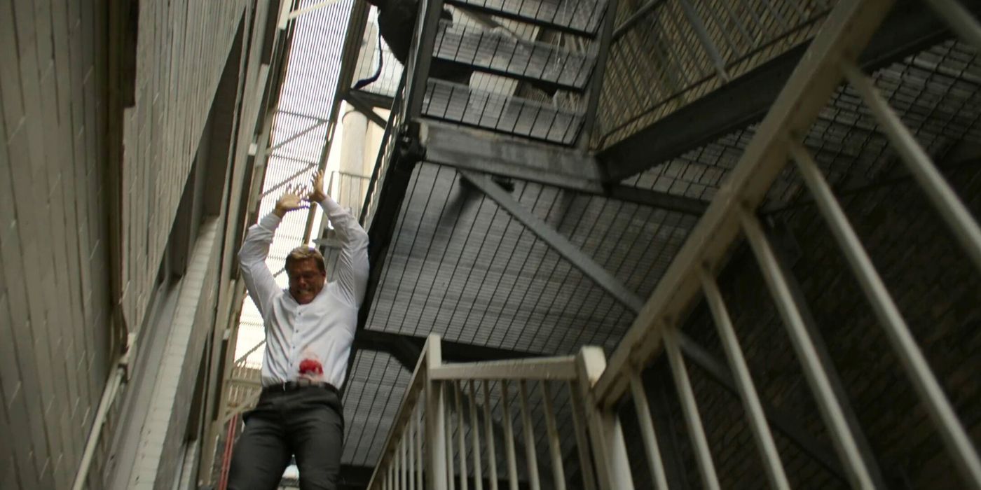Jack Reacher dangles from a stairwell in Reacher season 1