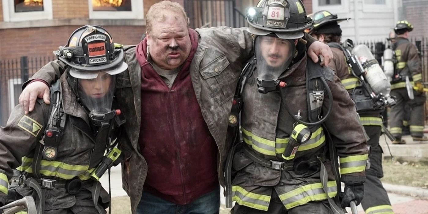 Two firefighters carrying a man away from a burning building in We Called Her Jellybean, Chicago Fire