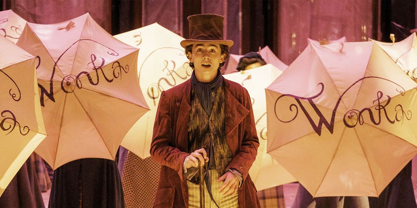 Willy Wonka sjunger med paraplyer med sitt namn bakom sig i Wonka