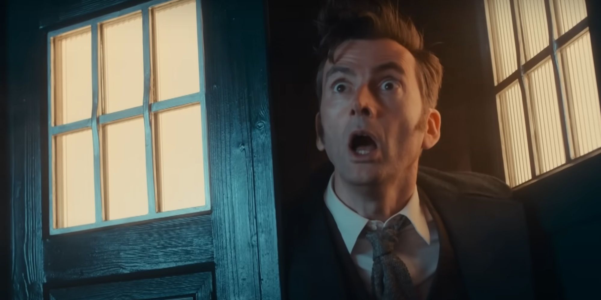 David Tennant as the Fourteenth Doctor leaning out of his TARDIS in the 2023 Children In Need special looking shocked