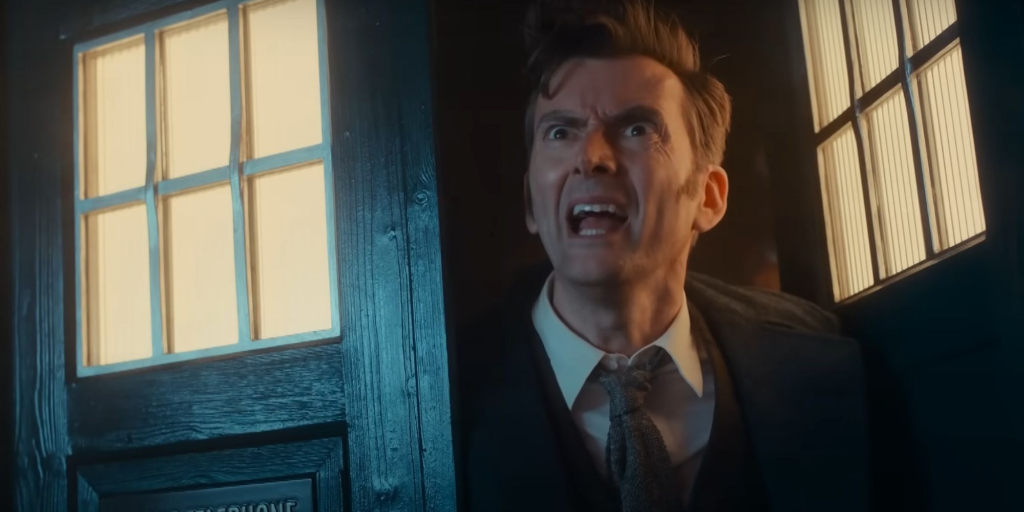 David Tennant as the Fourteenth Doctor leaning out of his TARDIS in the 2023 Children In Need special looking confused
