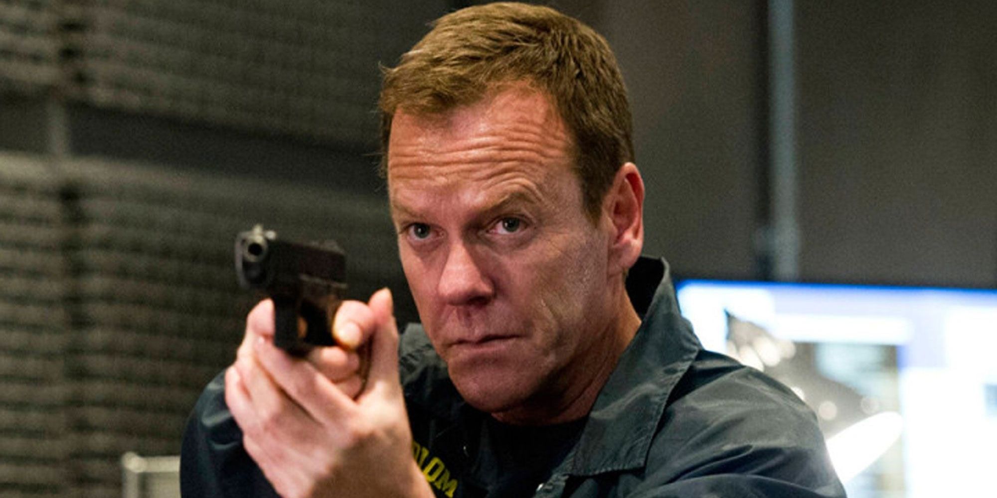 Kiefer Sutherland as Jack Bauer holding a gun in 24 