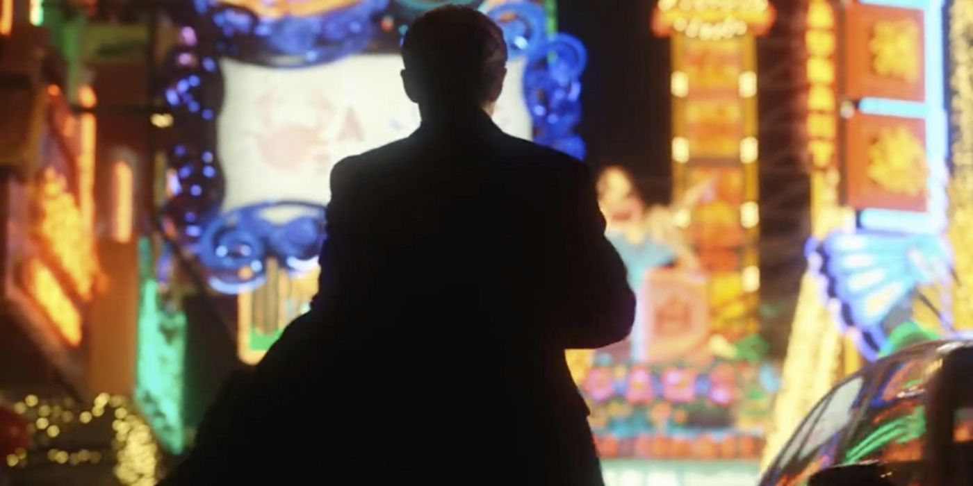 A man walking through a brightly lit city street in Blossoms Shanghai.