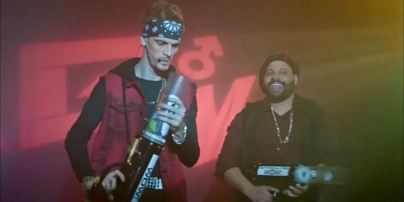 Aaron Carter as P.T. Cruiser about to point a t-shirt cannon in his face as Colton Dunn smiles behind him in Angie Tribeca. (1)