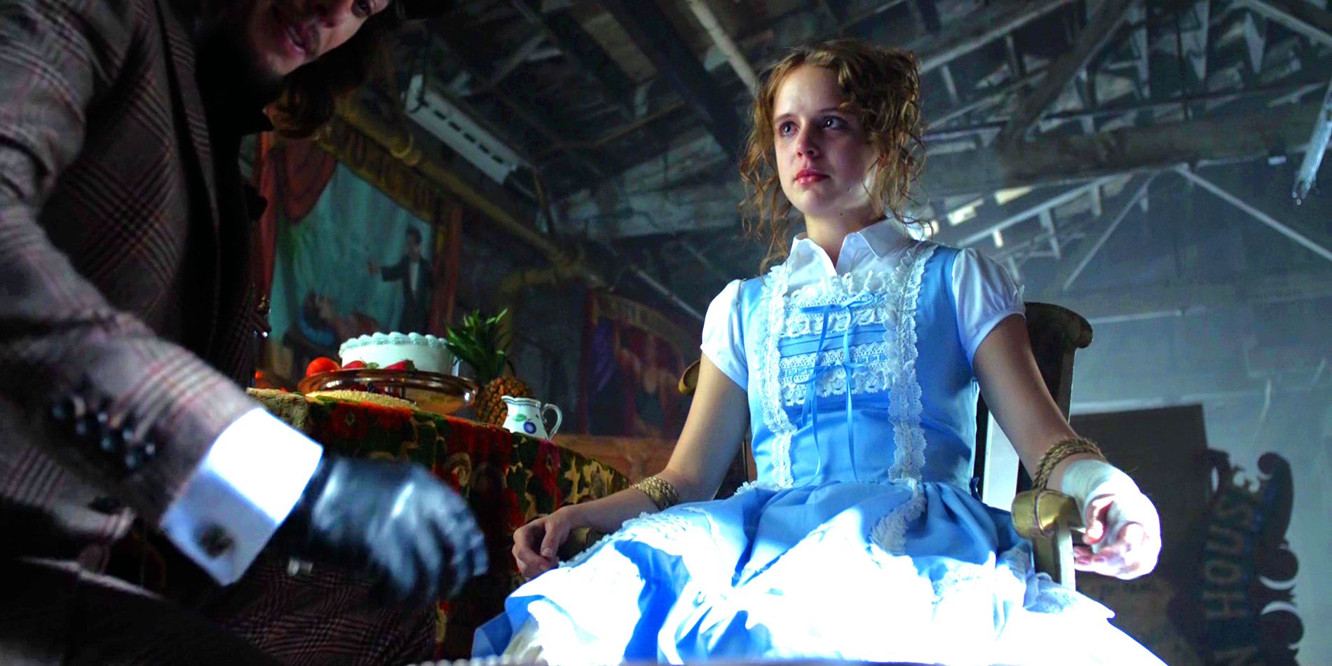 Alice Tetch looking at her brother Jervis while tied to a chair, dressed like Alice in Wonderland in Gotham