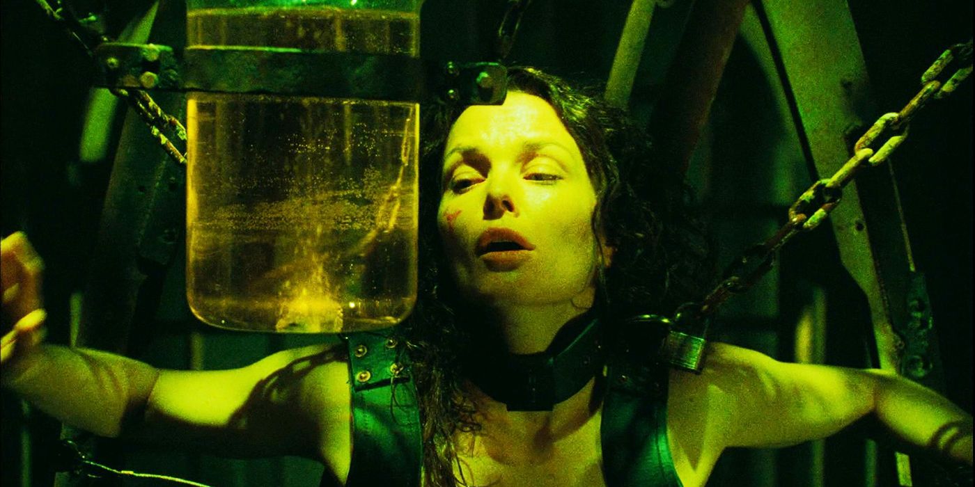 Dina Meyer as Allison Kerry chained to the angel trap with a jar of acid in front of her in Saw 3