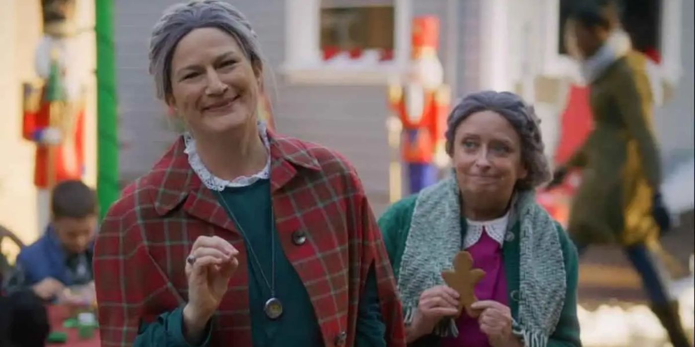 Hildy (Ana Gasteyer) as Hildy smiling with Marga (Rachel Dratch) behind her in A Clusterfunke Christmas.