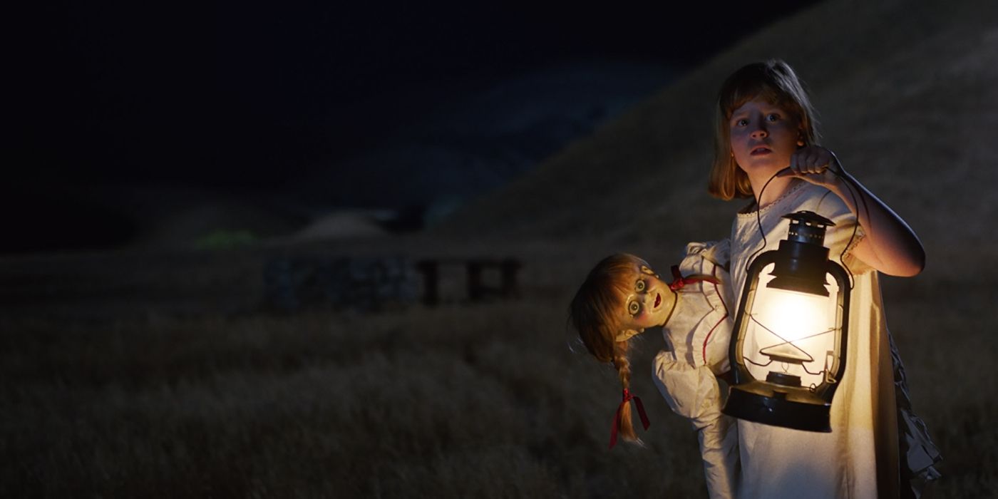 Uma menina segurando a boneca Annabelle