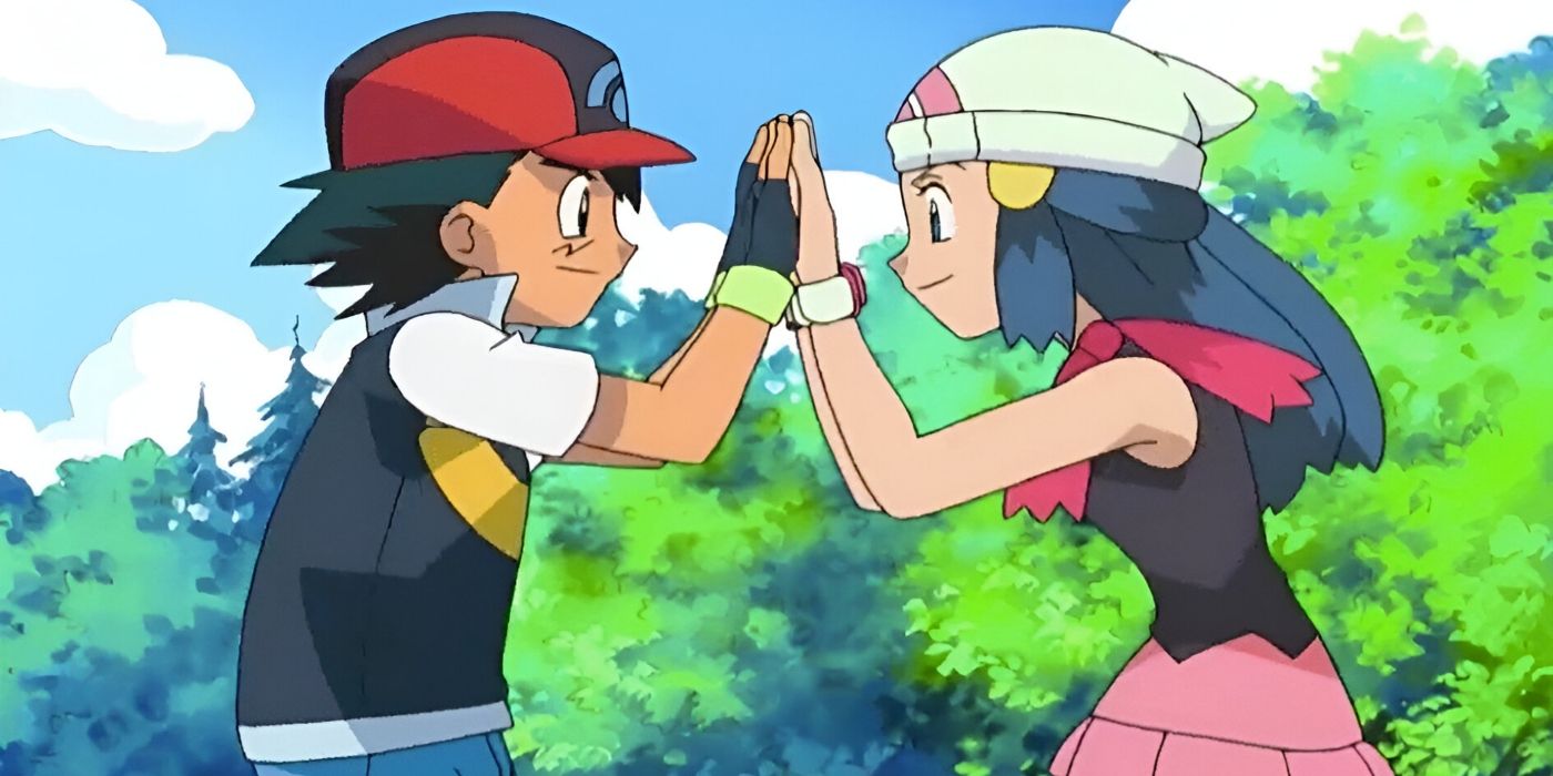 A boy in a red hat and a girl in a white hat smile as they high five each other.