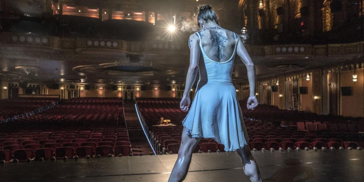 Ballerina - A ballerina with back tattoos dancing on stage to an empty audience