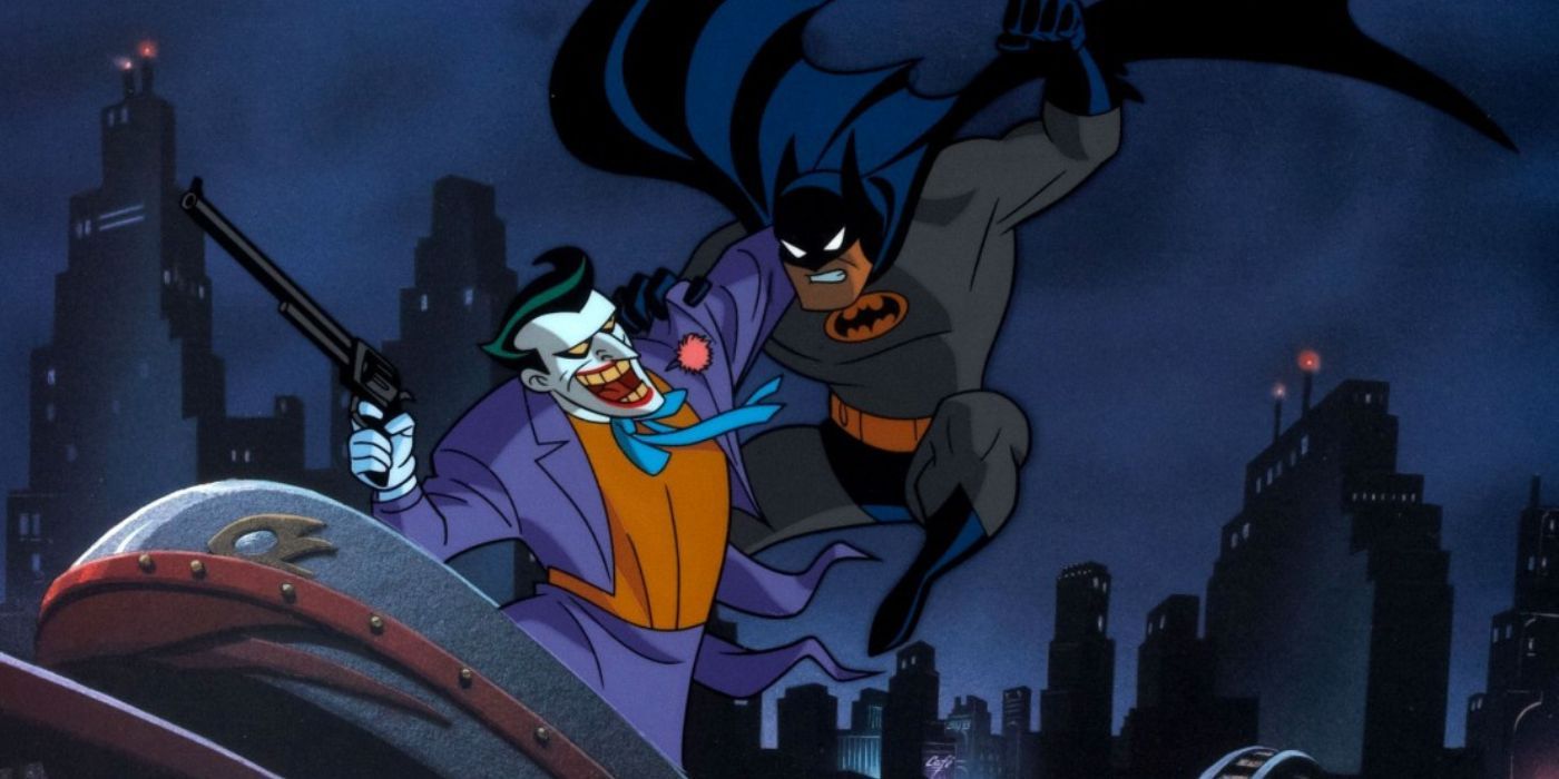 Batman leaping at Joker who is holding a gun and laughing while riding a toy train in Batman Mask of the Phantasm