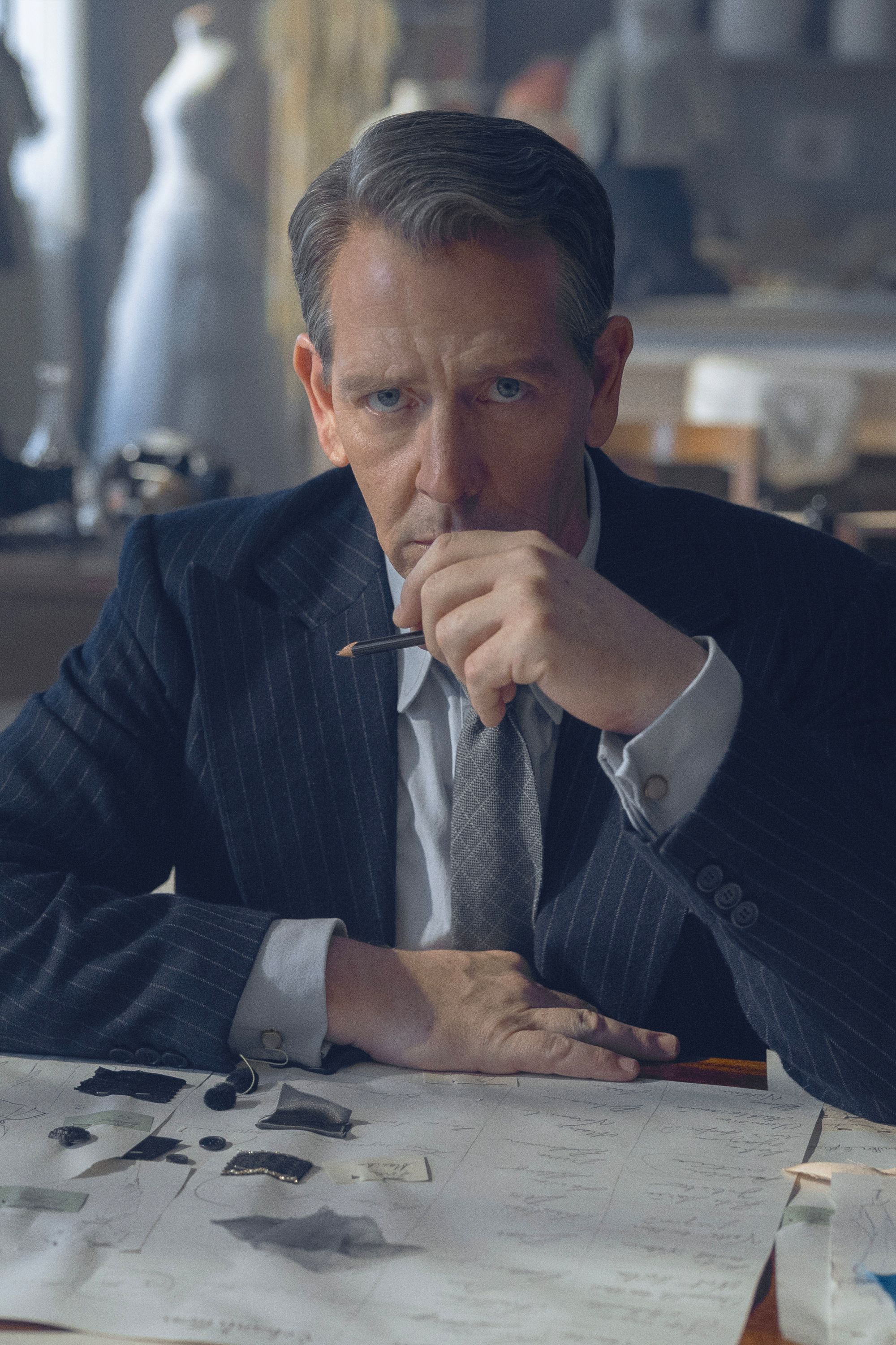 Ben Mendelsohn as Christian Dior Looking Over Fashion Papers in The New Look