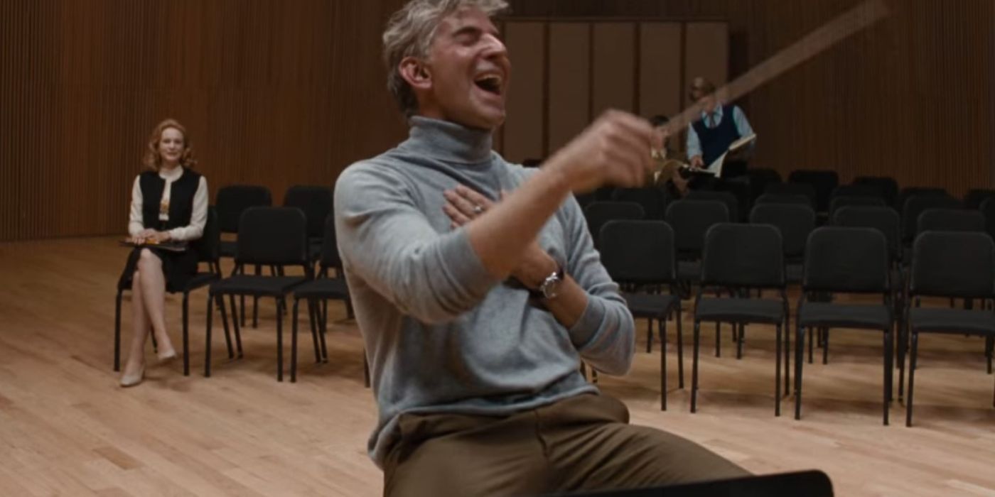 Bradley Cooper as Leonard Bernstein teaching in Maestro with Carey Mulligan's Felicia in the background