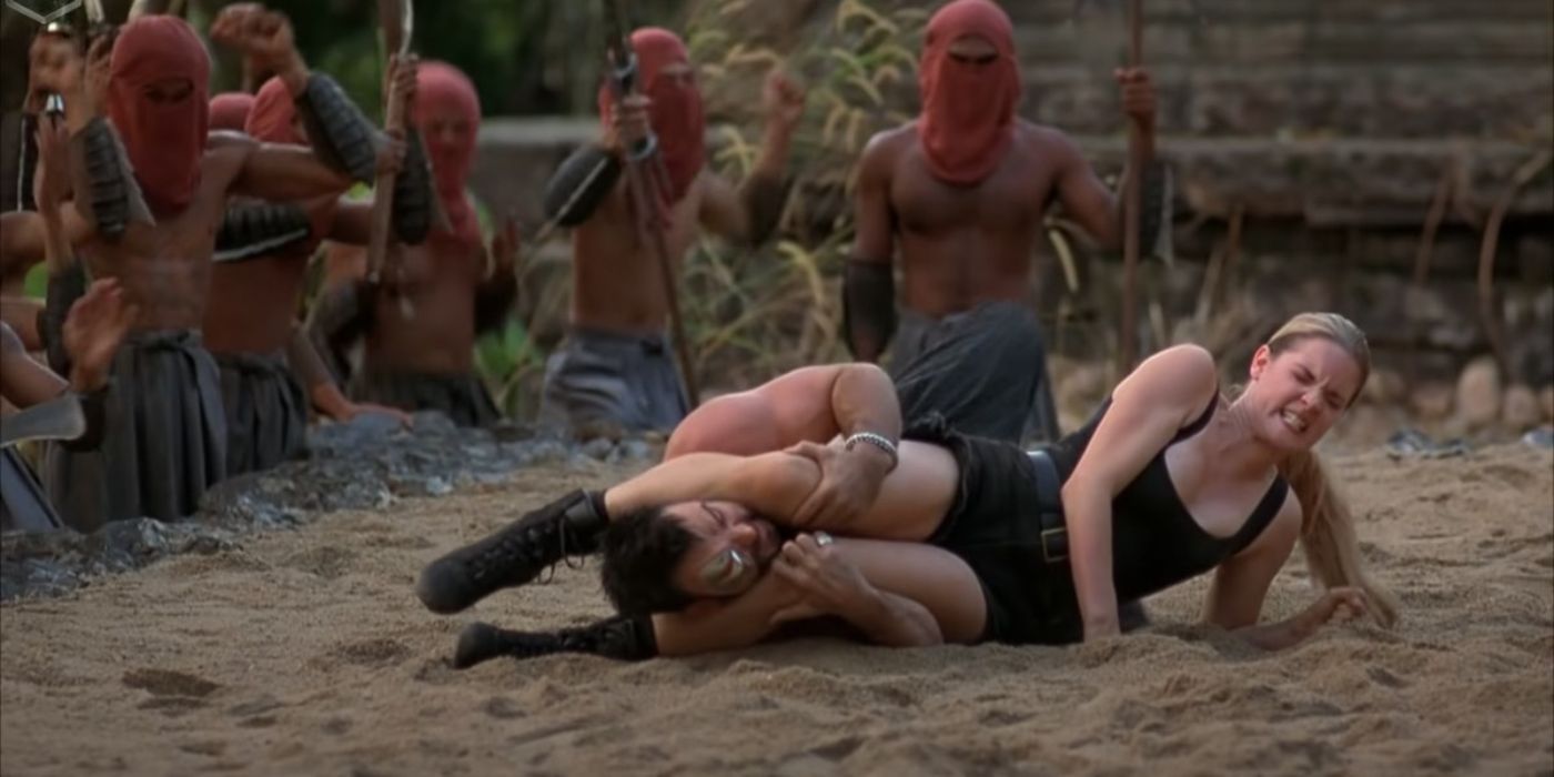Bridgette Wilson as Sonya Blade fighting Trvor Goddard as Kano in the sand in Mortal Kombat (1995)