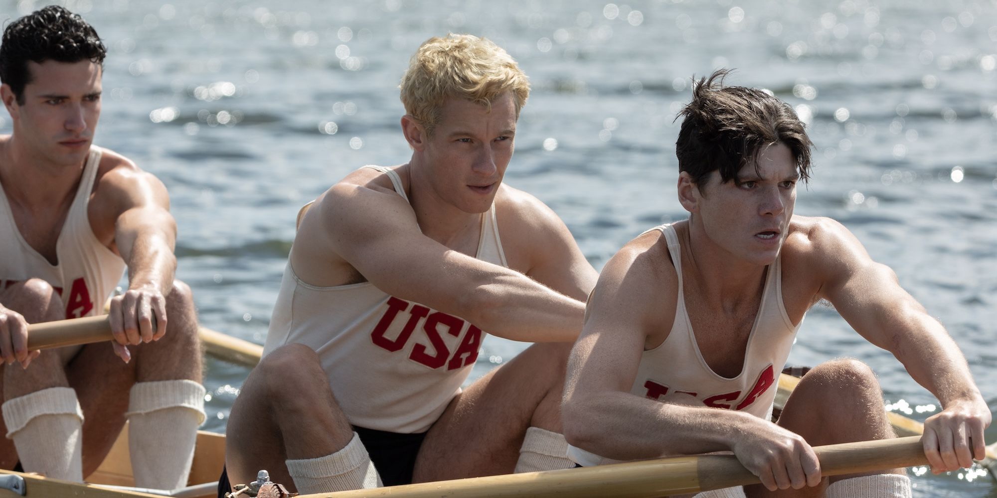 callum turner rowing alongside two others in the boys in the boat