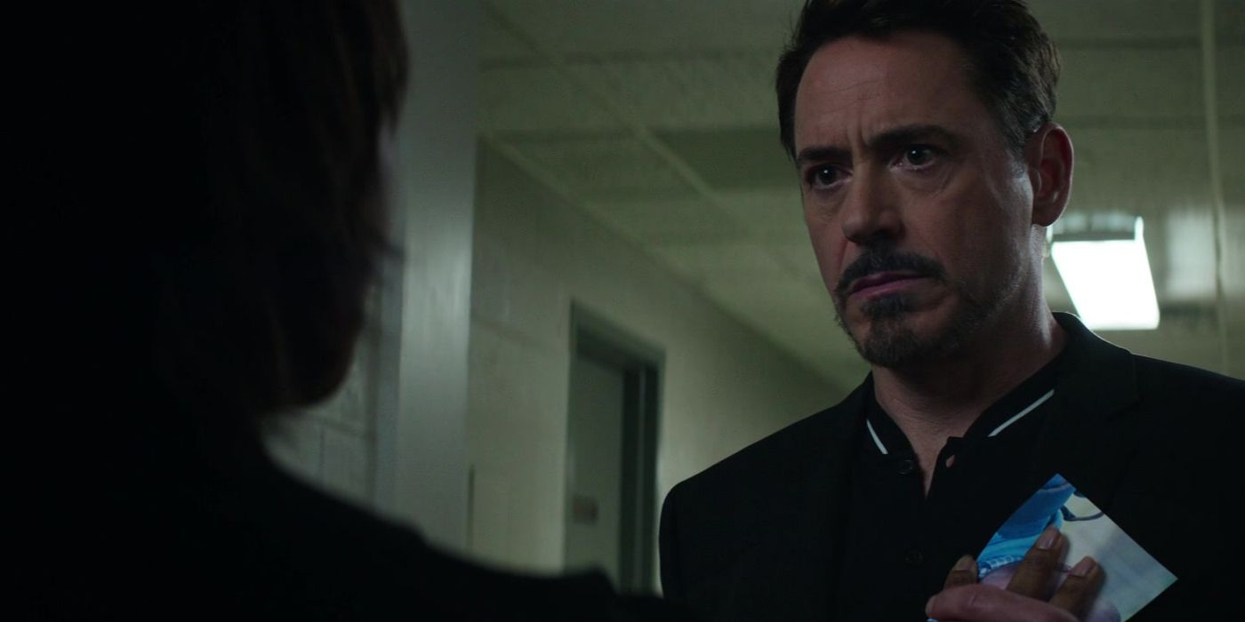 Robert Downey Jr. as Tony Stark in Captain America: Civil War being handed a picture of Charlie Spencer