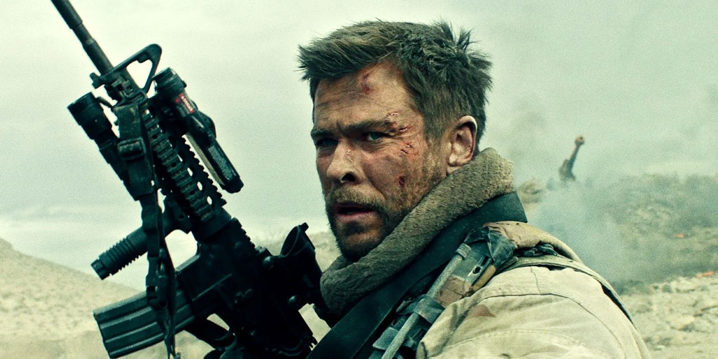 Chris Hemsworth holding a gun while covered in dirt and blood as Mitch Nelson in 12 Strong.