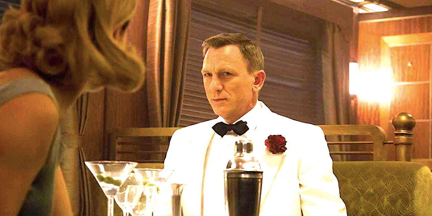 Daniel Craig's James Bond frowns in a white tuxedo with a martini on a train in Spectre