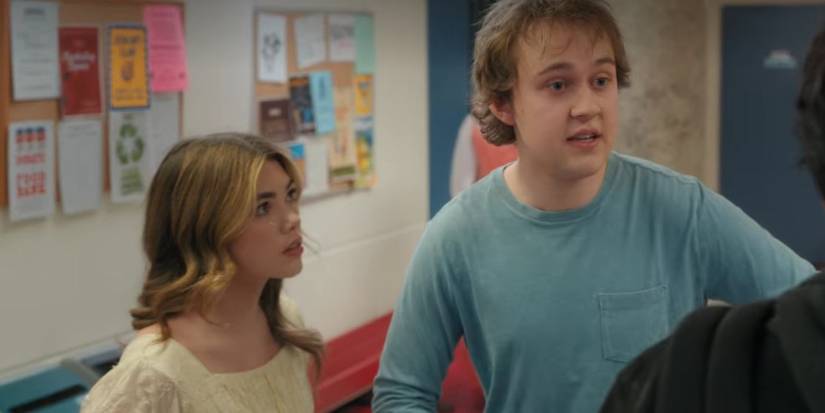 Danny explains something to someone offscreen as Erin watches him intently in My Life with the Walter Boys 