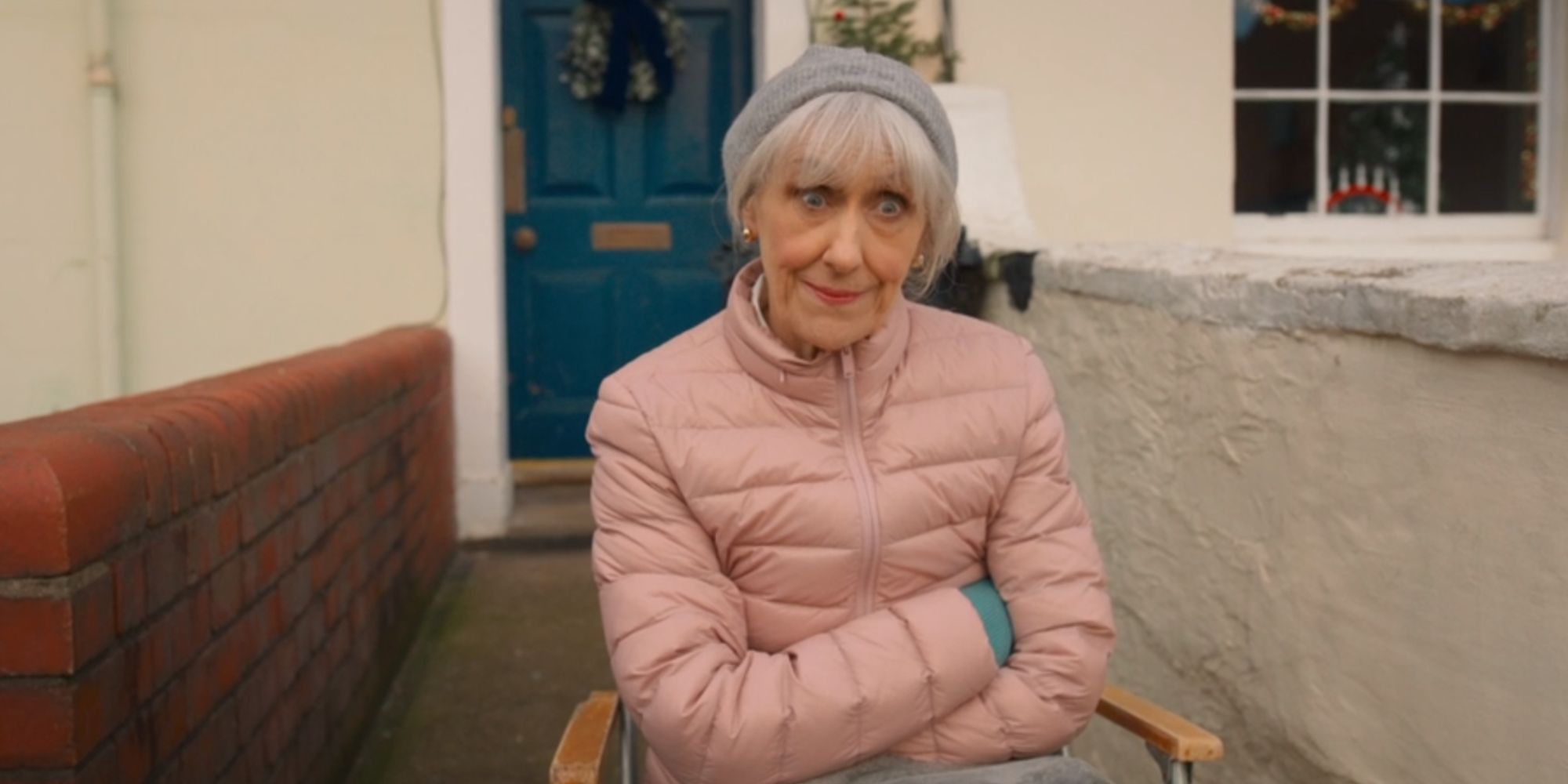 Anita Dobson as Mrs Flood crossing her arms outside her house in Doctor Who