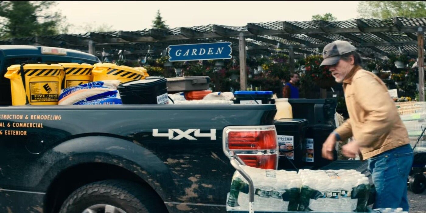 Kevin Bacon as Danny loading water bottles onto his truck with yellow buckets that have the E-Corp label from Mr. Robot in the Netflix film Leave the World Behind
