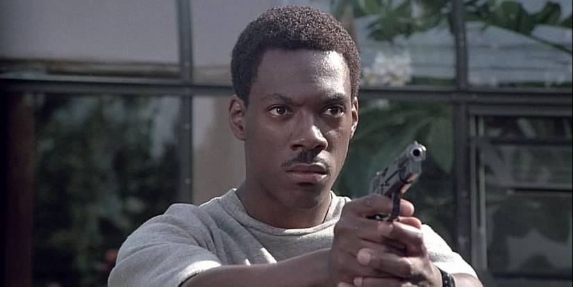 Axel Foley (Eddie Murphy) aims his gun at an off-screen criminal in Beverly Hills Cop.