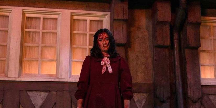 Ester outside of a burning house with blood on her face in Orphan First Kill