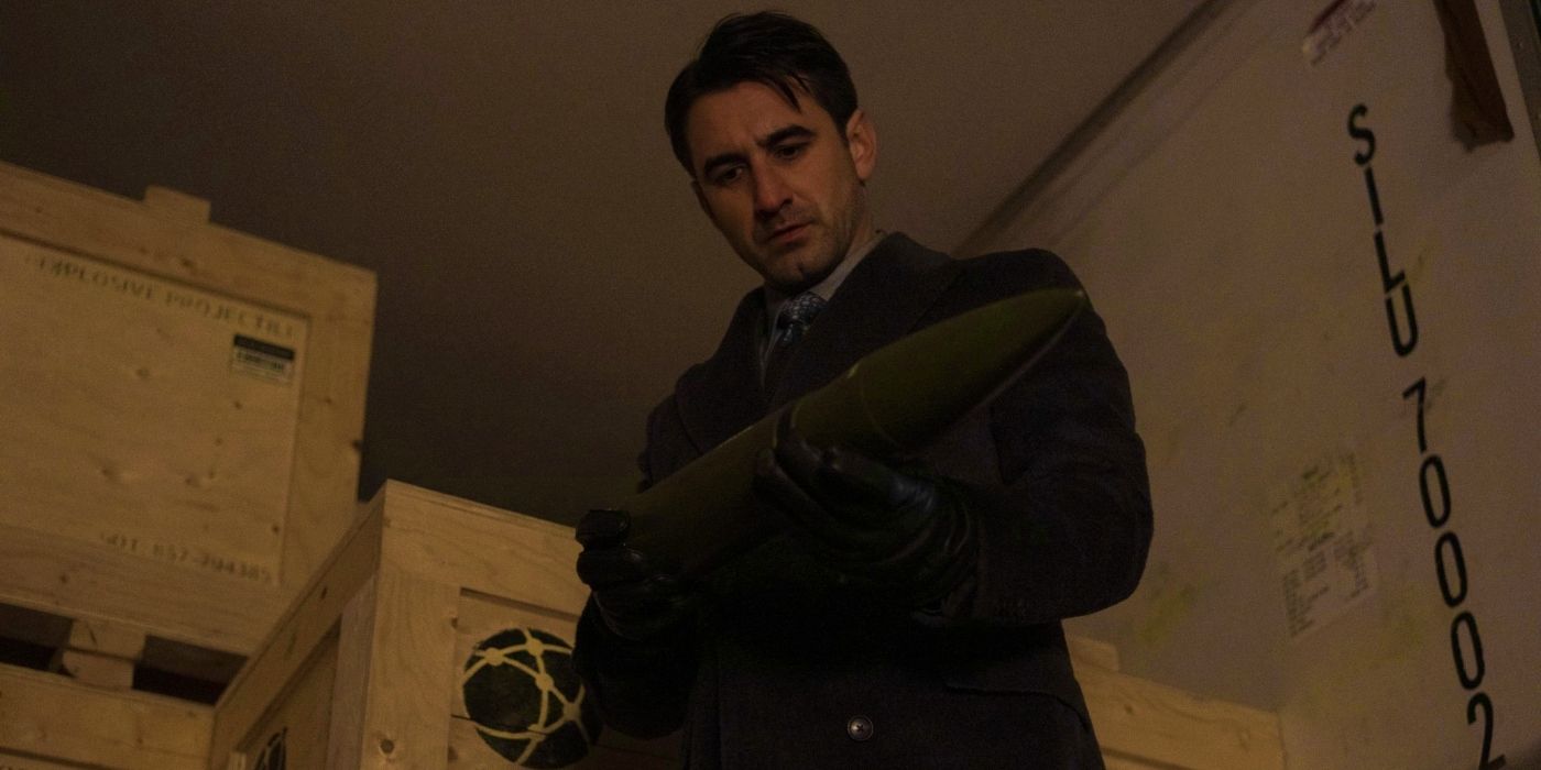 Ferdinand Kingsley as AM holding the Little Wing missile in Reacher season 2
