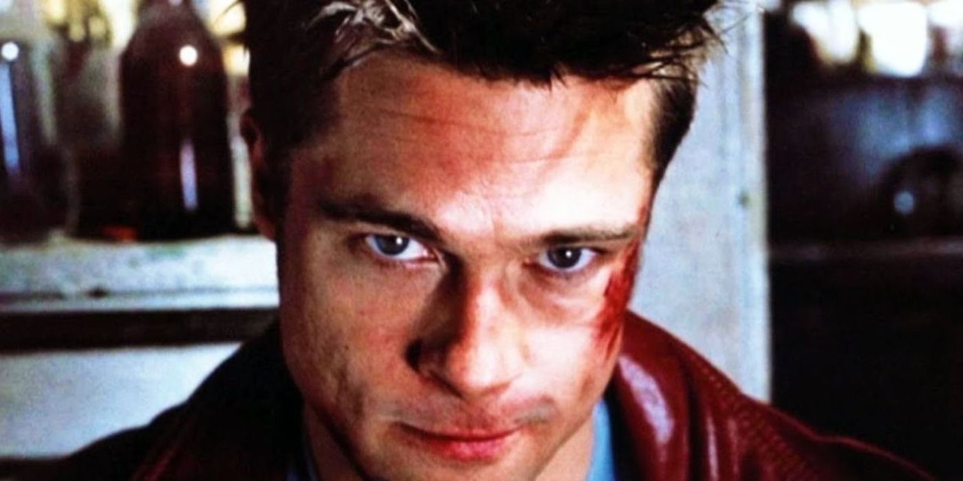 Brad Pitt, como Tyler Durden, olha ameaçadoramente para a câmera com sangue no rosto em Clube da Luta.