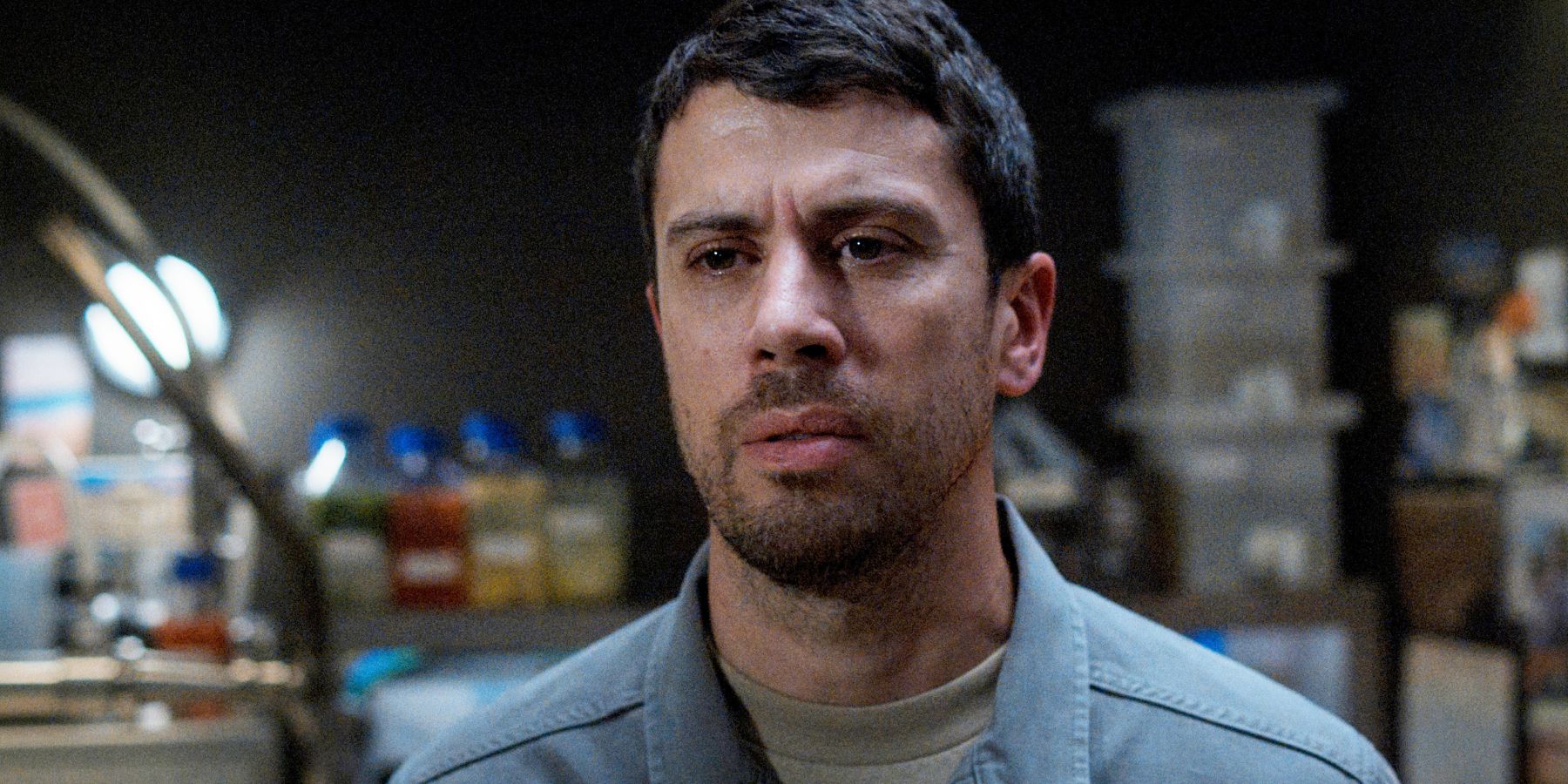 Miles stands at Ilya’s bar, in front of the still and bottles of moonshine