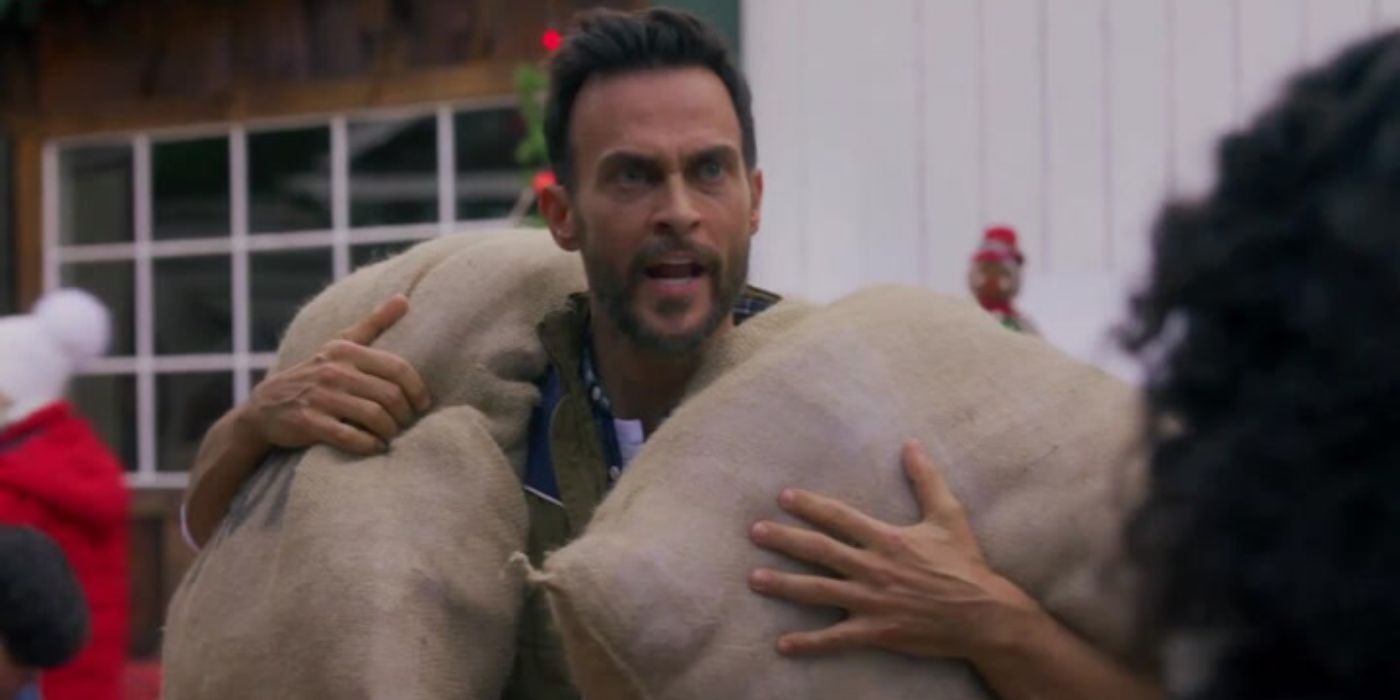 Frank (Cheyenne Jackson) carrying two sacks and yelling at someone in A Clusterfunke Christmas.