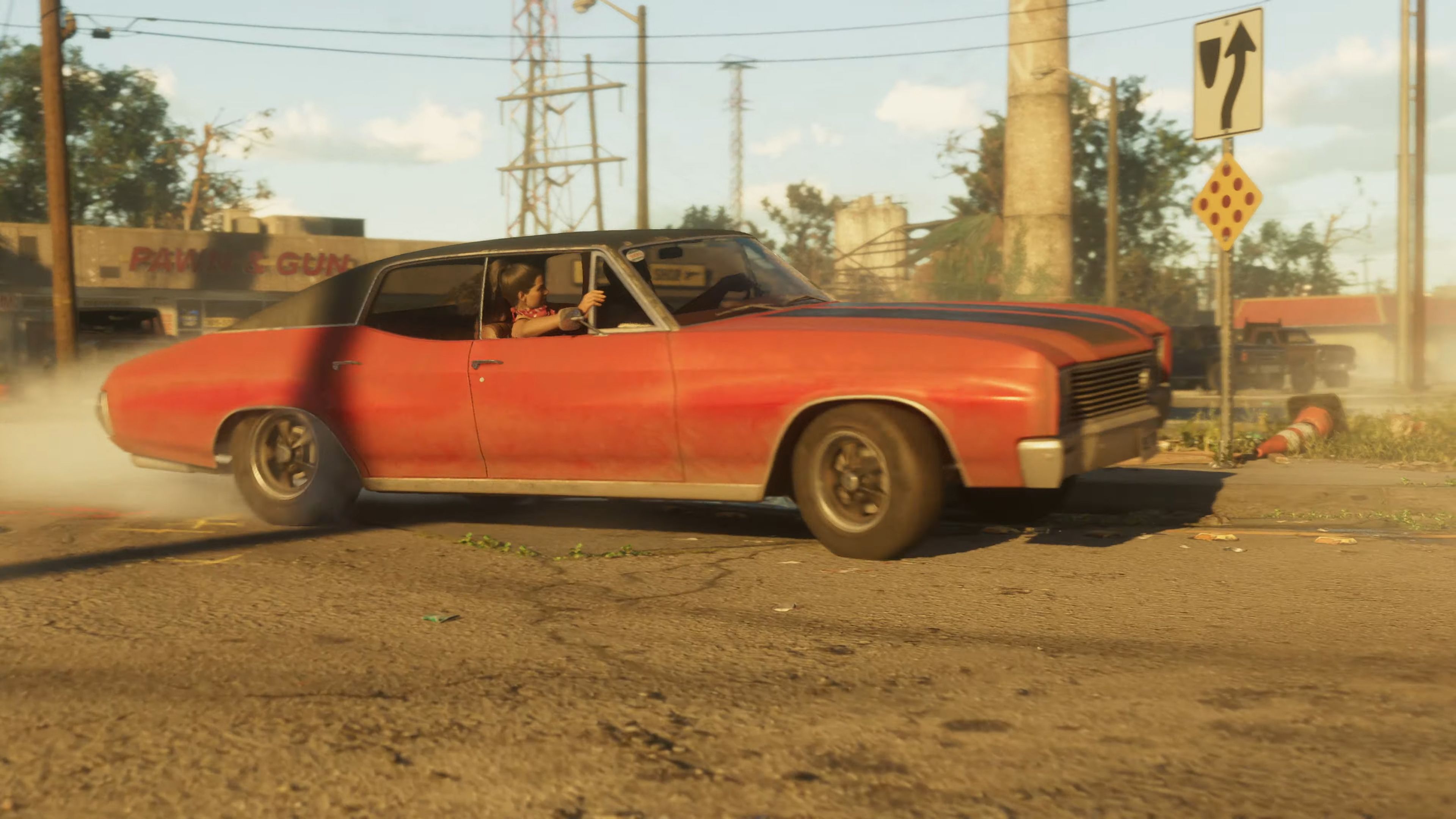 Lucia and Jason drift around a corner in a red car during a high-speed chase