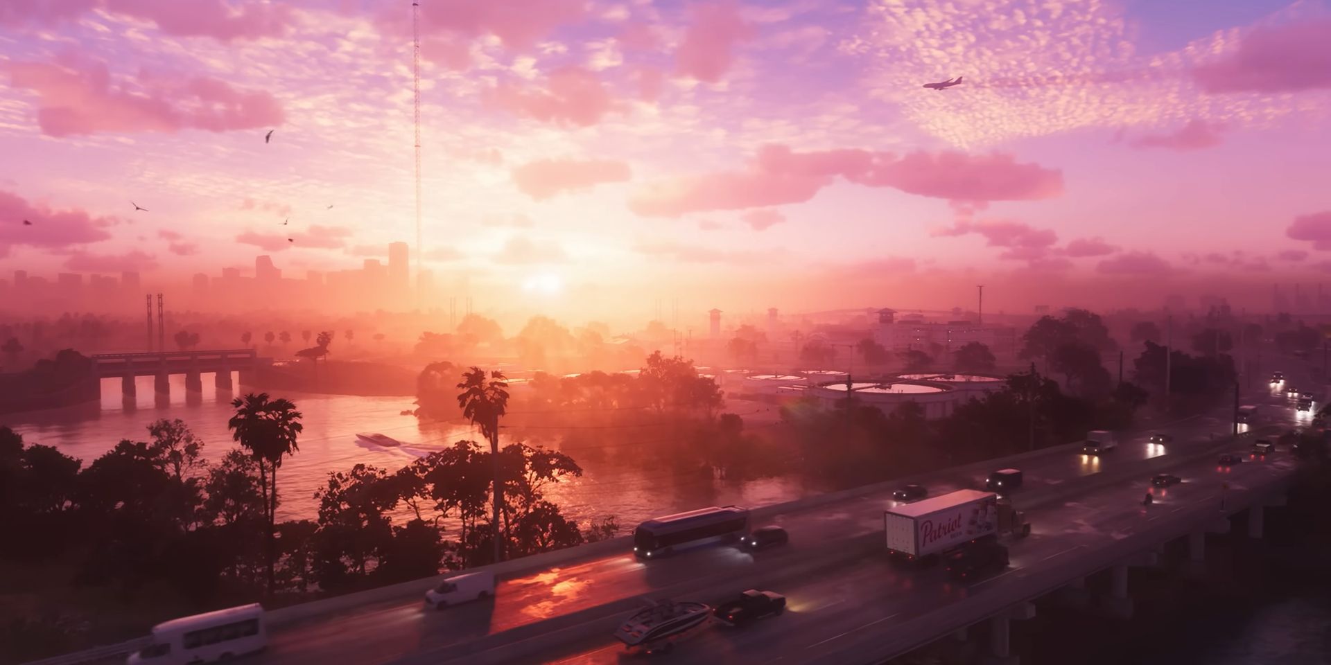 Una vista aérea de Vice City en una captura de pantalla del tráiler de GTA 6.  Una puesta de sol baña todo con una luz púrpura y dorada mientras autos y camiones retumban por una autopista bordeada de palmeras a lo largo de una bahía.  A lo lejos, algunos hoteles se alzan contra el horizonte mientras un avión vuela justo debajo de unas nubes irregulares.